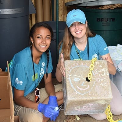 Two teen girls volunteering to make animal enrichment