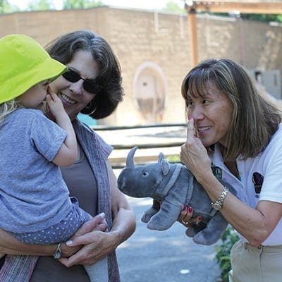 Volunteer teaching a child about a rhino's horn